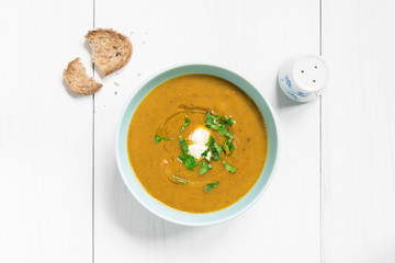 Mushroom soup garnished with fresh parsley on white table