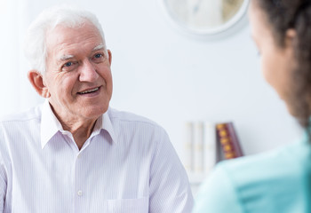 Senior man talking to caregiver