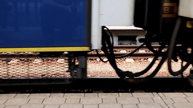 Start the train from the railway station. Undercarriage of wagon ride along the tracks beside platform.
