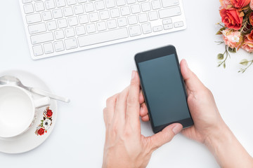 Business person working on smart phone with white workspace