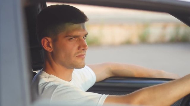 portrait of a young man behing the wheel, slow-motion