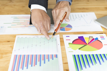 businessman analyzing and discussing with tablet and paperwork d