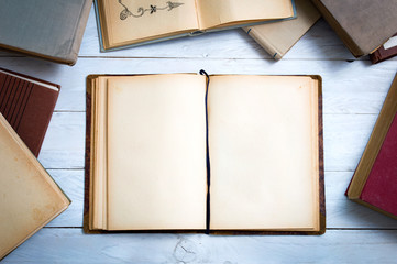 Old books on white wooden desk with empty pages for your text