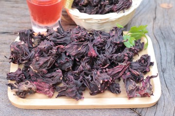 Dry roselle and roselle juice on wood background.