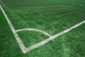 Obraz premium Football soccer field corner with white marks, green grass texture.