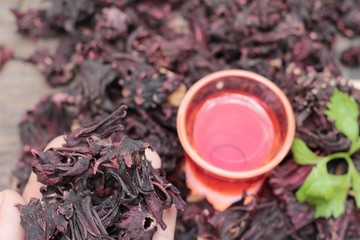 Dry roselle and roselle juice on wood background.