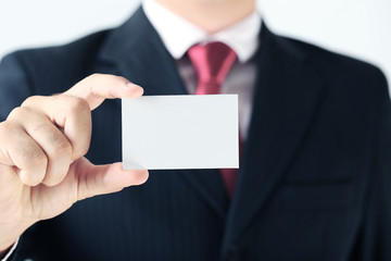 Businessman holding blank card in his hand