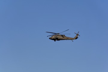 Fototapeta na wymiar The military helicopter UH-60 Black Hawk against the blue sky .