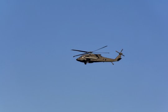 The military helicopter UH-60 Black Hawk against the blue sky .