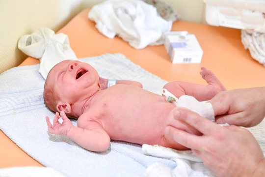 Baby nach der Geburt wird gewickelt