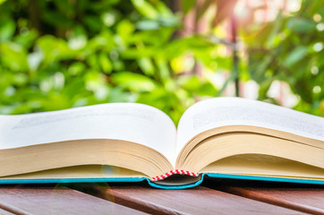Open Book on a Wooden Table Outdoor. 