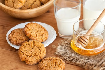 Honey ginger cookies with milk on a rustic background, selective focus