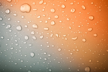 Drops of water on a color background. Gray - orange. Toned