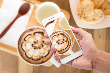 A cup of coffee with flower latte art on top and bread heart and hot pandan juice.