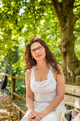Fototapeta premium charming woman sitting on park bench
