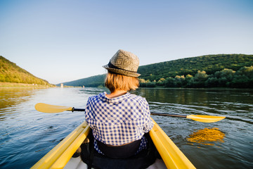 Caucasian woman is relaxing in kayak on the river. Ukraine.