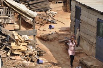 Frau mit Handy in einem Slum in Afrika