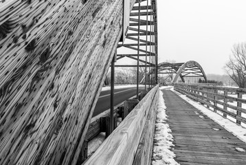 Image of two bridges on a snowy winter day. Wooden bridge with road background. Minimal architecture design. Architectural detail. Black and white.