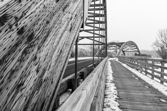 Fototapeta Image of two bridges on a snowy winter day. Wooden bridge with road background. Minimal architecture design. Architectural detail. Black and white.