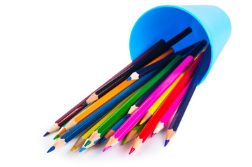Fototapeta premium Colored pencils in a blue glass isolated on white background
