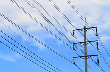 Electrical pole with power lines against hazy blue sky