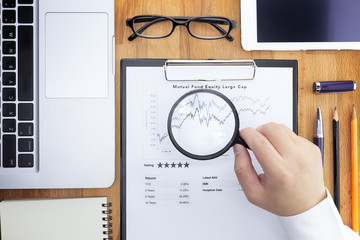 Businessman or Fund manager review Mutual Fund information with performance line graph and...