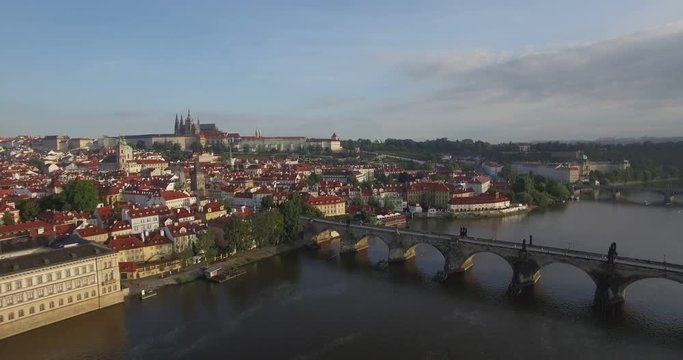 Aerial camera slowly moves away from Prague castle, the Charles Bridge and River Vltava are in shot. Shot at dawn in 4K