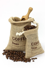 Fresh coffee beans in a bag with scoop on white background