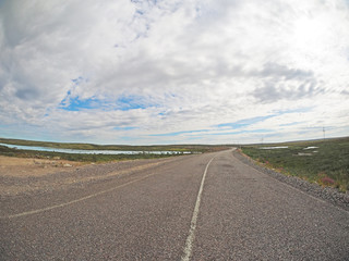 Fototapeta na wymiar asphalt road in tundra in the north of Russia