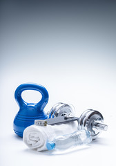 Fitness Equipment. Kettlebell towel dumbbells water smart phone with headphones and measuring tape.