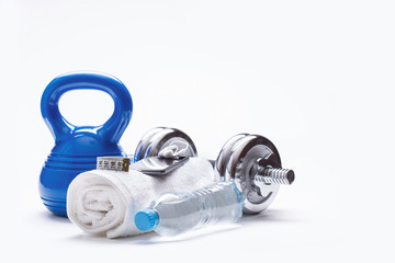 Fitness Equipment. Kettlebell towel dumbbells water smart phone with headphones and measuring tape.