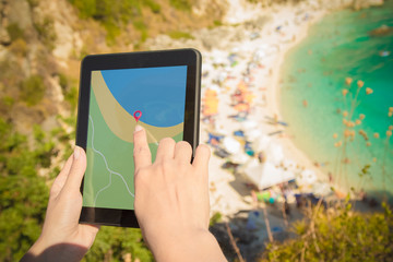 Female hands holding digital tablet device with gps navigation map application on the hill above...