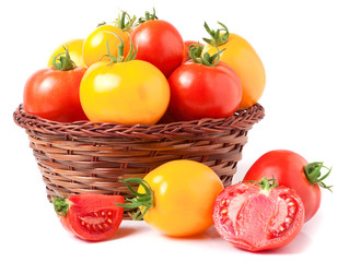 red and yellow tomatoes in a wicker basket isolated on white background