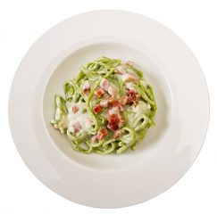 dish of green spaghetti with bacon and cream