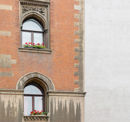 Obraz premium old brick wall with arched windows and a wall of gray plaster