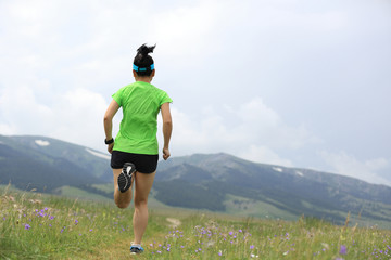 Obraz premium healthy lifestyle woman trail runner running on grassland