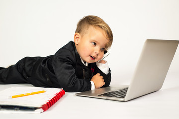 a child in the role of office manager with laptop and phone