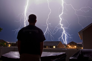 Lightning strike past man watching