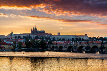 Cityscape of Prague with Castle and Charles Bridge at dramatic sunset, Czech Republic