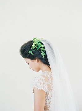 Bride wearing long veil and green leaves in hair