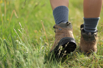 young woman hiker walking on trail in grassland