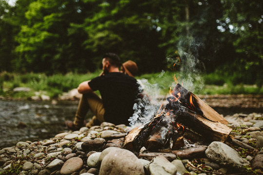 Couple sitting near campfire