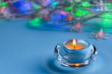 Christmas and winter holidays. Candle on blue background.