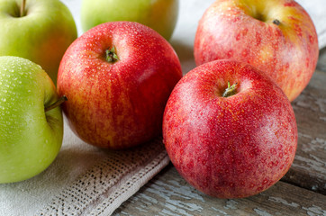 Red and green apples with drops of dew.