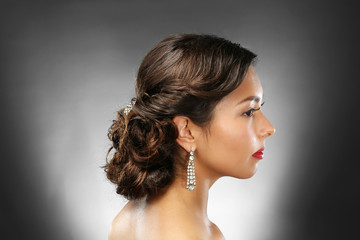 Young beautiful woman with nice hairdo on dark background