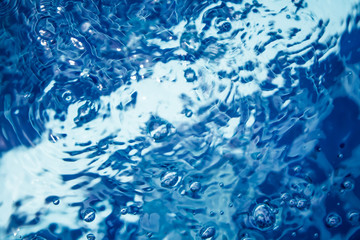 clear blue water with bubbles and ripples in swimming pool