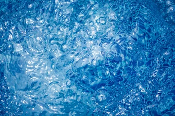 Abwaschbare Fototapete Wasser vibrant blue whirling water background with bubbles and ripples