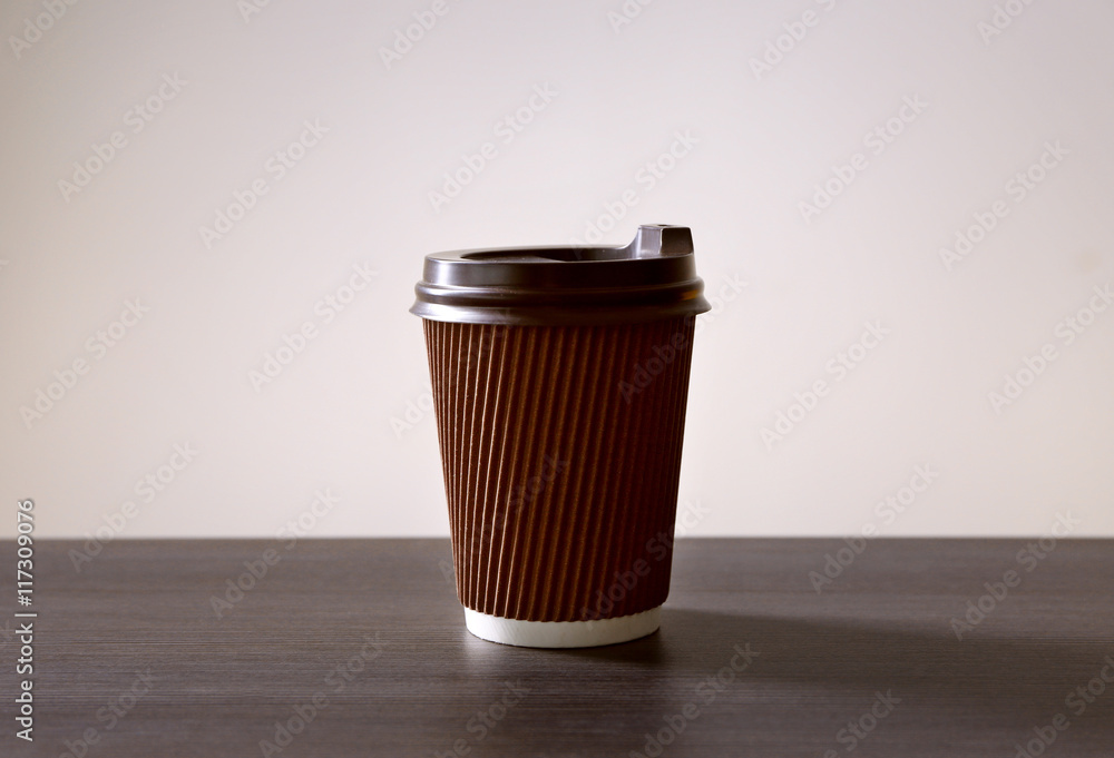 Wall mural Paper cup of coffee on light background