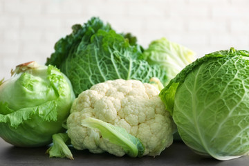 Different kinds of fresh cabbage on brick wall background