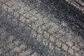 Sand tyre mark on black asphalt texture.